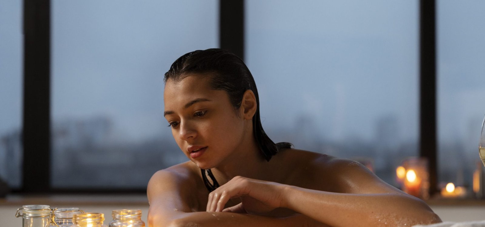 young-woman-relaxing-looking-candles-while-taking-bath